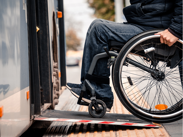Une personne en chaise roulante qui rentre dans un autobus